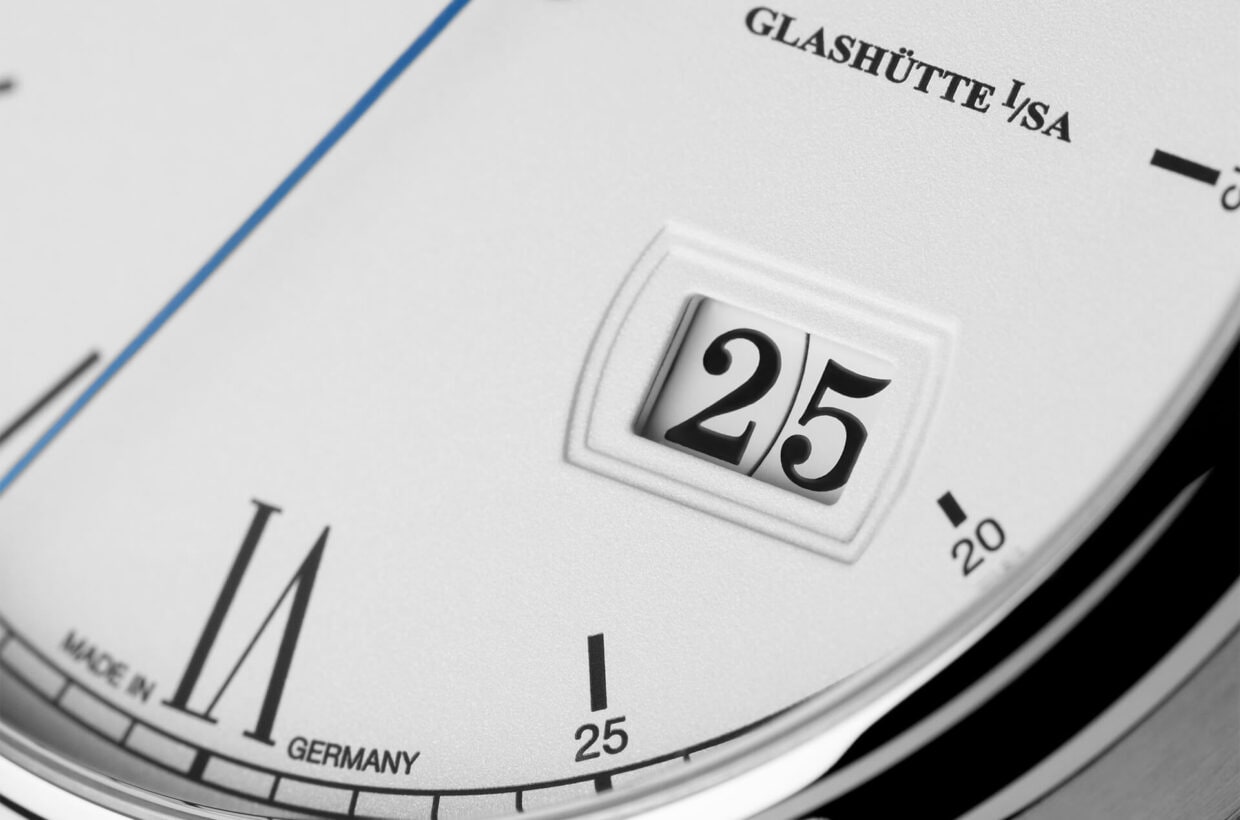 Fecha panorámica típica Junto con la fase lunar, este reloj concede el lugar de honor a la famosa fecha panorámica de la marca. Dos discos de indicación dispuestos de forma concéntrica y montados en el mismo nivel garantizan la legibilidad óptima de la fecha sin barra de separación central. Fecha panorámica típica Junto con la fase lunar, este reloj concede el lugar de honor a la famosa fecha panorámica de la marca. Dos discos de indicación dispuestos de forma concéntrica y montados en el mismo nivel garantizan la legibilidad óptima de la fecha sin barra de separación central.