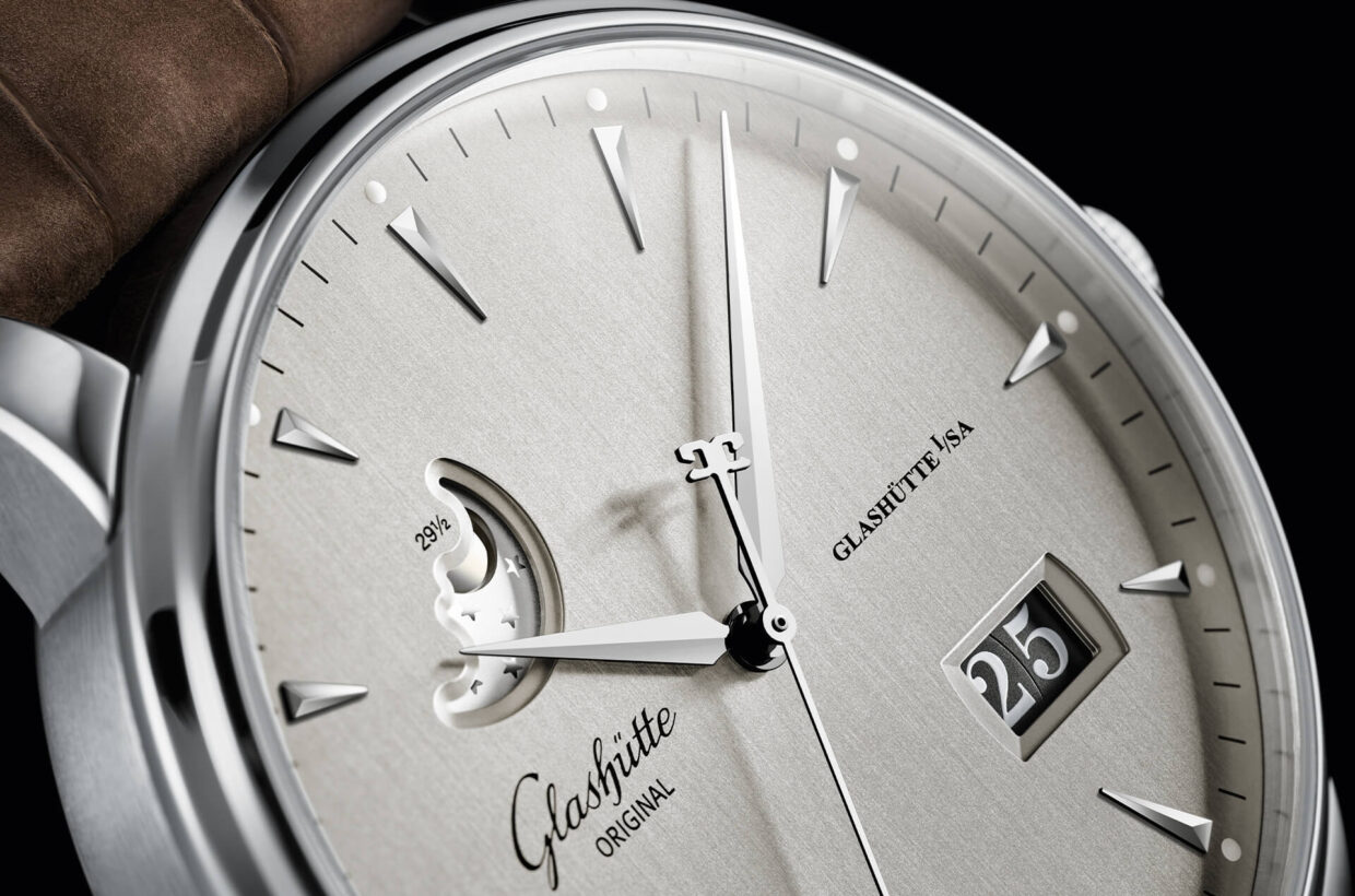 Fase lunar sofisticada El indicador de fase lunar está elaborado con todo detalle a mano en nuestra manufactura. Un cuidadoso fresado con diamante reproduce la elegante curva de la luna, cuya silueta convexa aparece realzada por un cielo estrellado azul galvanizado. Fase lunar sofisticada El indicador de fase lunar está elaborado con todo detalle a mano en nuestra manufactura. Un cuidadoso fresado con diamante reproduce la elegante curva de la luna, cuya silueta convexa aparece realzada por un cielo estrellado azul galvanizado.