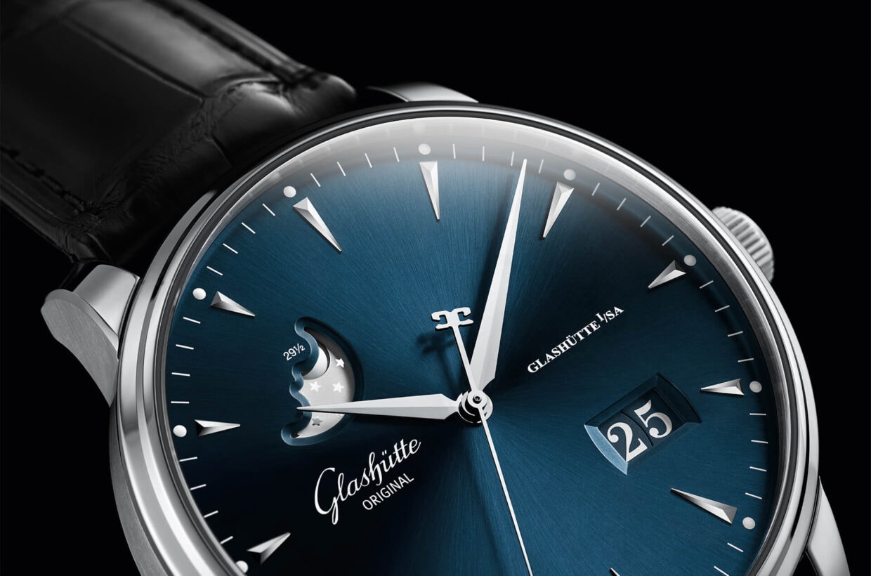 Blue dial Blue galvanised dial enhanced by delicate sunray finish, appliques in white gold, sword-shaped hands, Panorama Date with white numerals on blue background, silver-coloured moon phase display 