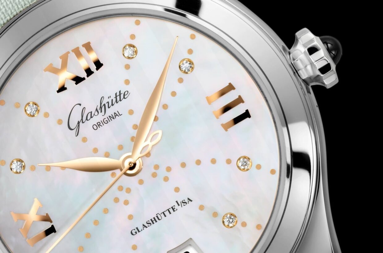 Mother-of-pearl dial Mother-of-pearl dial with delicate pastel shimmer, gold-plated applied Roman numerals, 8 brilliant-cut diamonds serve as hour indexes, gold-coloured decorative dots, hands in rose gold 