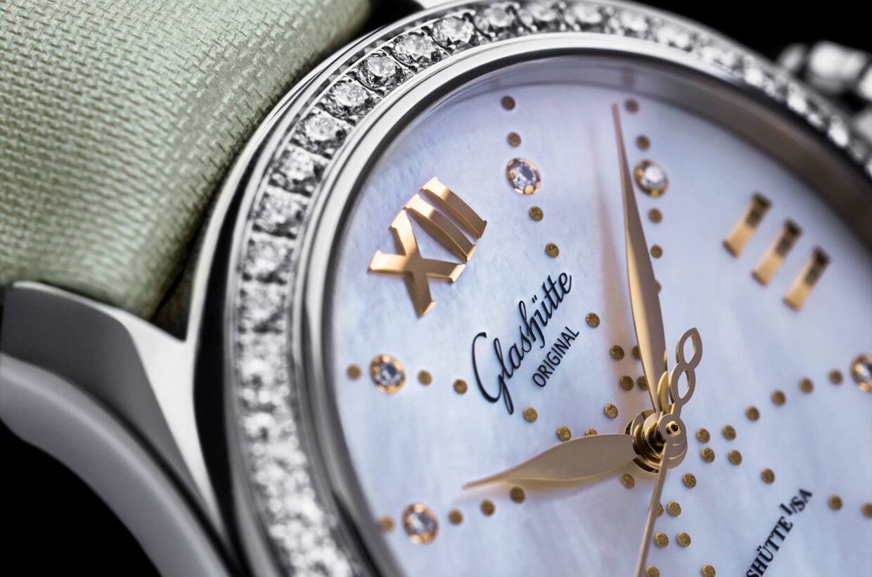 Mother-of-pearl dial Mother-of-pearl dial with delicate pastel shimmer, gold-plated applied Roman numerals, 8 brilliant-cut diamonds serve as hour indexes, gold-coloured decorative dots, hands in rose gold 