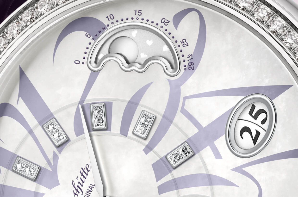 珍珠母贝表盘 白色珍珠母贝表盘搭配淡紫色不同尺寸的阿拉伯数字，条形时标镶嵌总计18颗明亮型切割钻石，白色18K金指针 